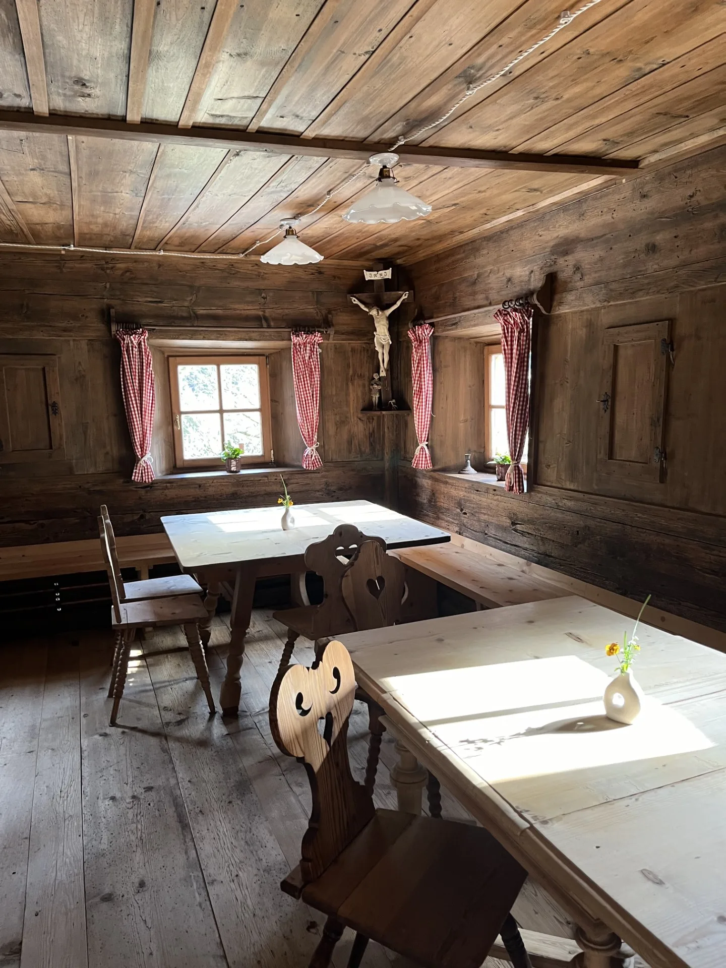 Stube tradizionale in legno del maso Orthammer con tavoli, panche e crocifisso d'epoca Stube tradizionale in legno del maso Orthammer con tavoli, panche e crocifisso d'epoca